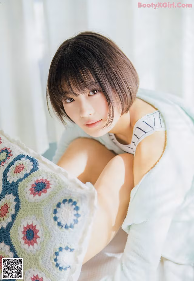 A woman laying on top of a bed covered in a blanket.