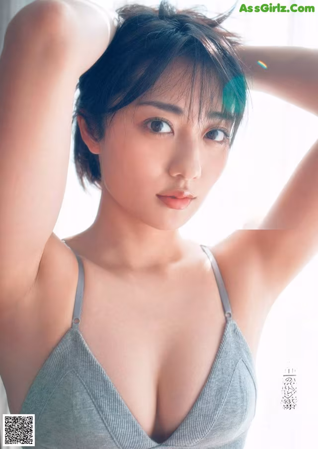 A woman in a gray bra top posing for a magazine.