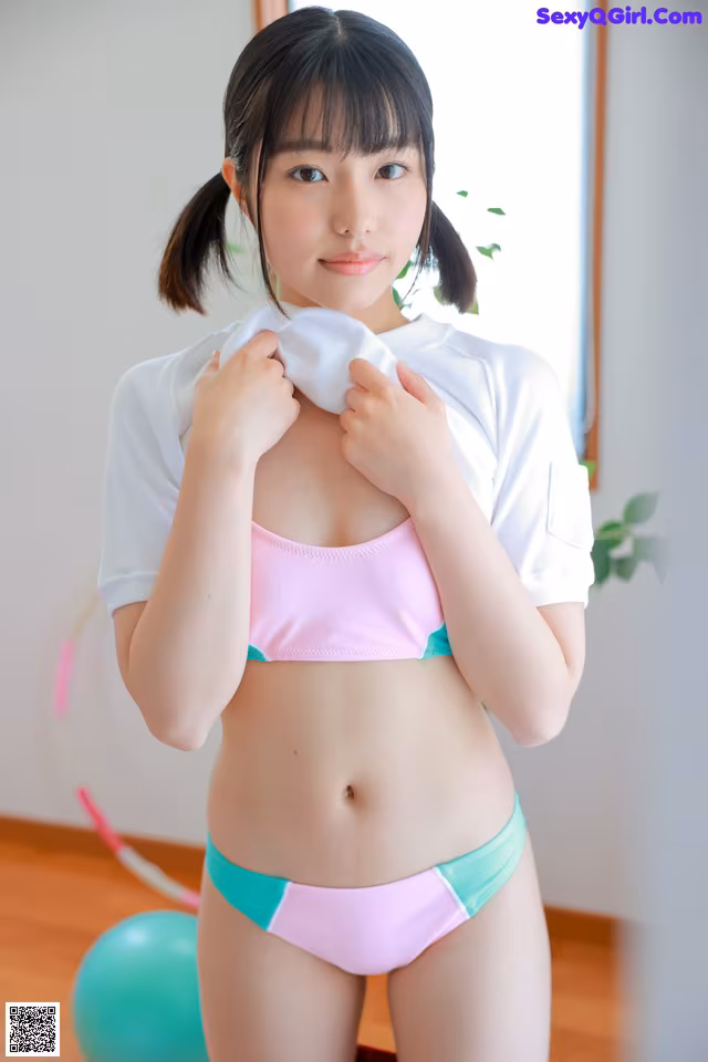 A woman in a pink and green bikini posing for a picture.
