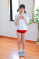 A woman in a white shirt and red shorts posing for a picture.