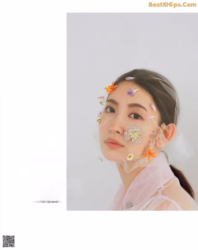 A woman with flowers on her face in a magazine.
