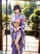 A woman in a purple kimono posing for a picture.