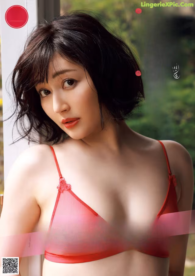 A woman in a red bra and panties posing for a magazine.