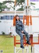 A woman in a military uniform sitting on a ladder.