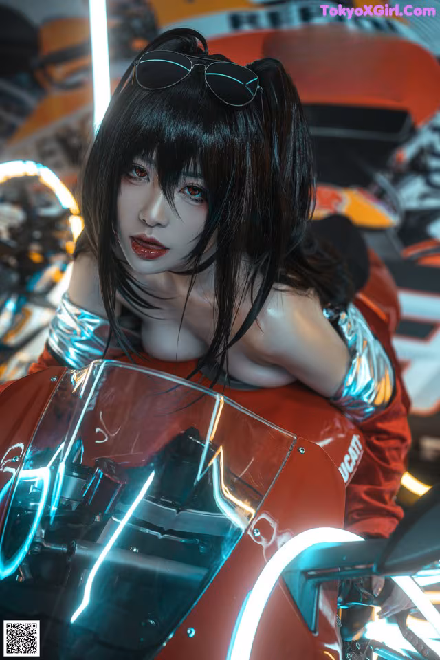 A woman sitting on top of a red motorcycle.
