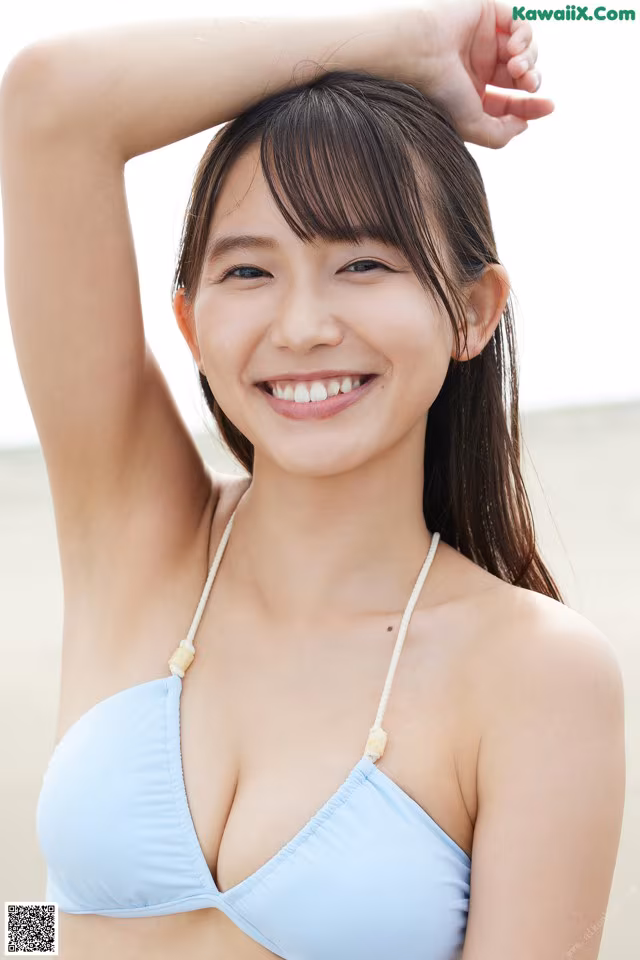 A woman in a blue bikini posing for a picture.
