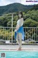 A woman standing on the edge of a swimming pool.